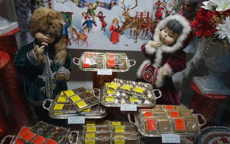 Geschmücktes Schaufenster des Café Heinemann mit Pralinen und Adventsdekoration.